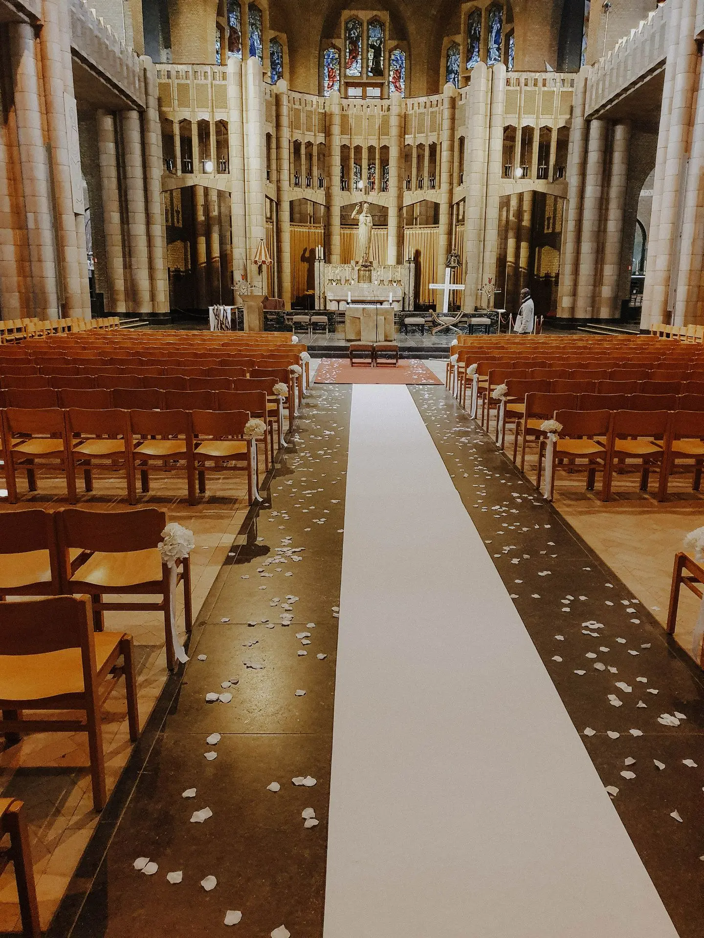 Allée église avec tapis blanc et pétales au sol