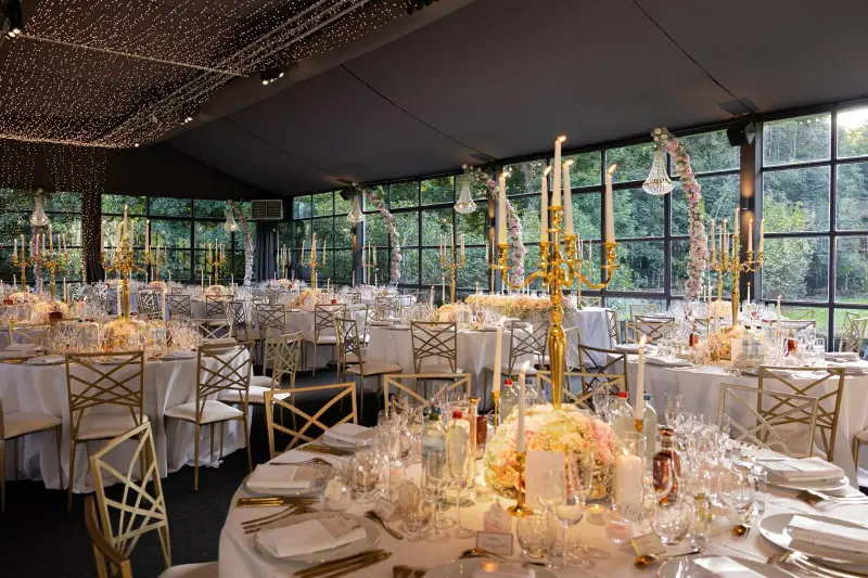 Décoration de mariage sous verrière : chandeliers dorés, centres de table fleuris et guirlandes lumineuses – Château de Terblock, mariage de L et L, septembre 2025