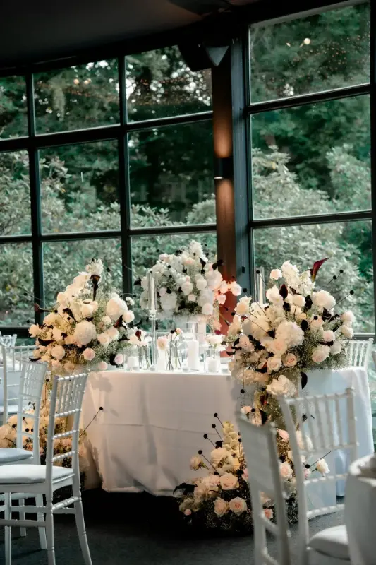 Centres de table de mariage en roses blanches et hortensias sur hauts supports – Château de Terblock, mariage de C et O, août 2025