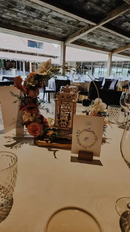 Décoration de table : fleurs séchées orangées, lanterne dorée et menu – Waerboom, mariage de E et T, juillet 2025