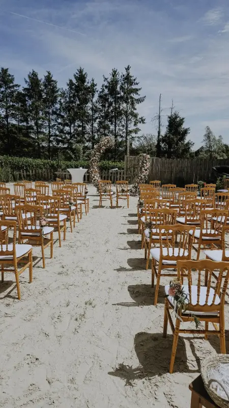 Cérémonie laïque en extérieur : allée et chaises en bois – Écuries Jean-Pierre Dal Fior, mariage de N et JP, juillet 2025