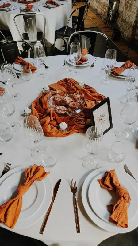 Décoration de table : serviette couleur rouille et menu noir – Buda Bxl, mariage de D et A, mai 2025
