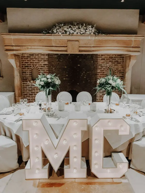 Lettres lumineuses géantes et compositions florales blanches sur table ronde – Waerboom, mariage de M et M, septembre 2023