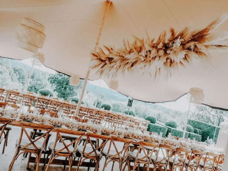 Réception sous tente avec suspension de fleurs séchées et chaises en bois – Manoir de Lébioles, mariage de N et A, août 2023
