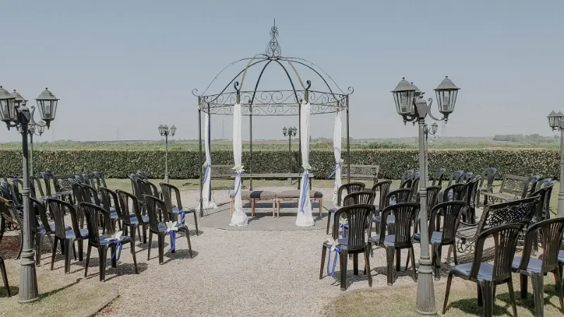 Cérémonie en extérieur avec kiosque blanc et chaises noires – Petit Versailles, mariage de C et O, mai 2023