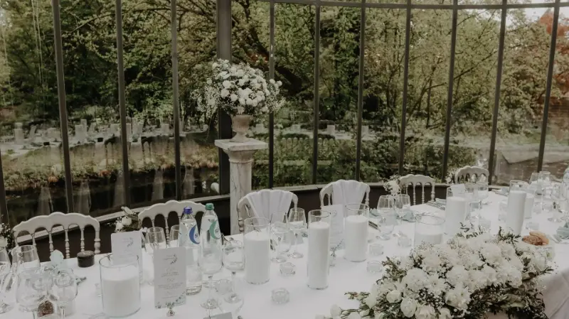 Véranda : compositions de fleurs blanches sur colonne – Château de Ruisbroek, mariage de M et V, mai 2023