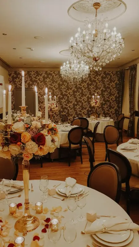 Composition de roses rouges et pêche sur chandelier – Château de Huizingen, mariage de D et T, décembre 2022