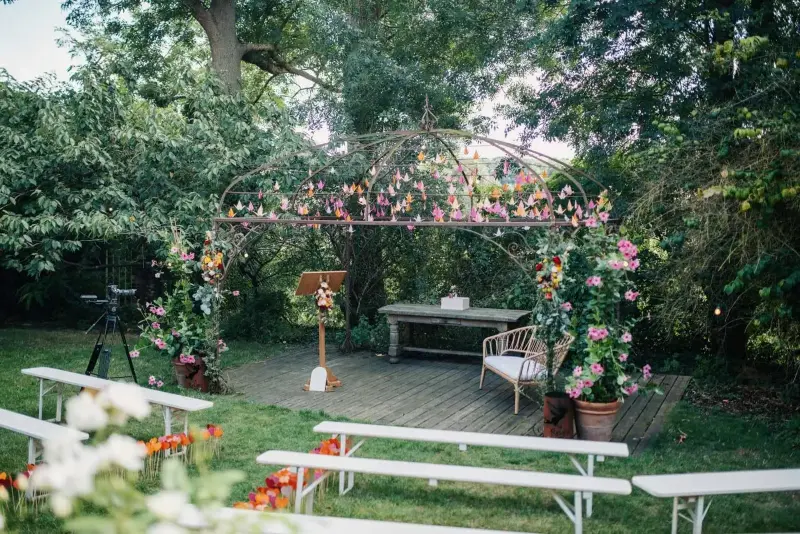 Cérémonie laïque dans un jardin : bancs blancs et arche fleurie – Relais des Rêves, mariage de S et P, août 2022