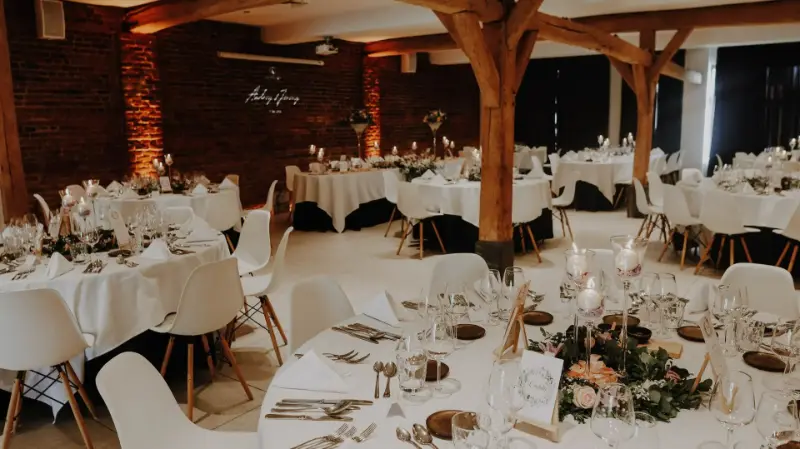 Salle à poutres en bois : tables rondes et verdure – Kattebroek, mariage de A et J, juin 2022