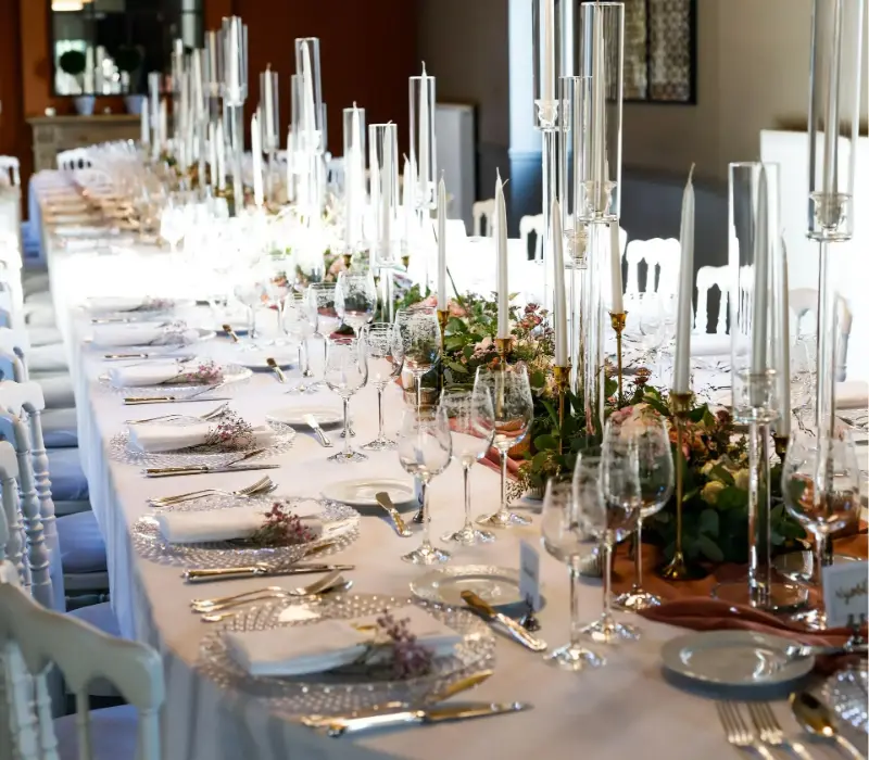 Longue table avec chandelles en verre et verdure – Manoir du Capitaine, mariage de T et P, octobre 2021