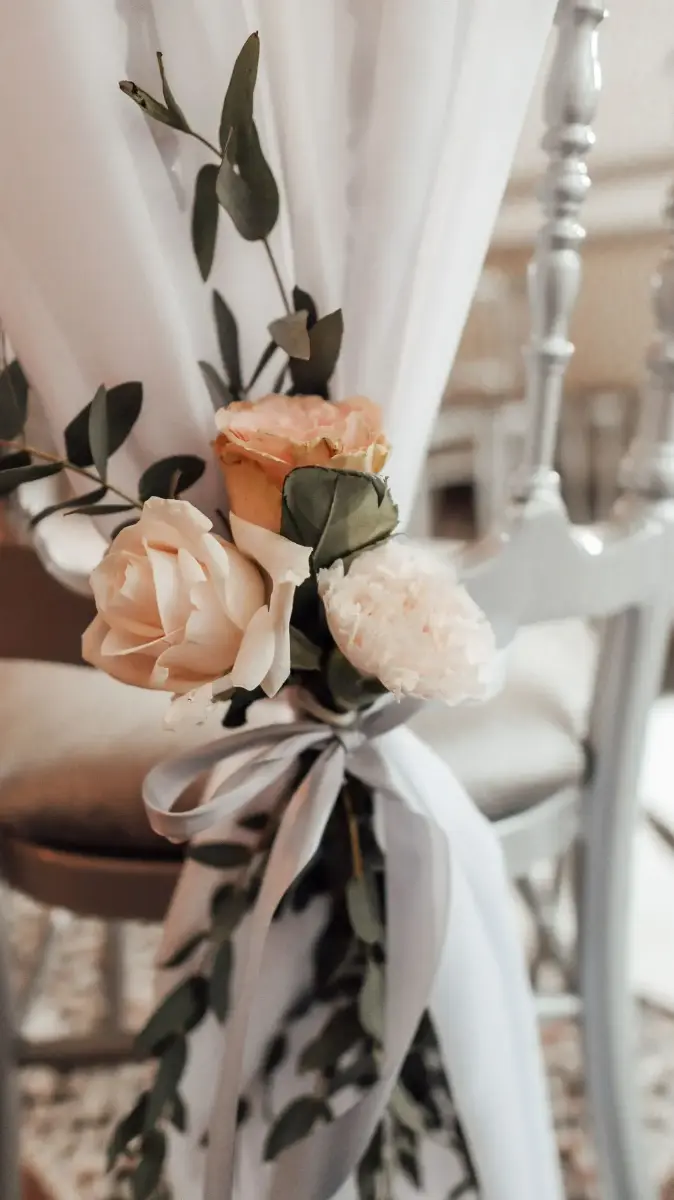 Bout de chaise décoré de roses pêche et blanches – Château de Ruisbroek, mariage de Meryam et Lorenzo